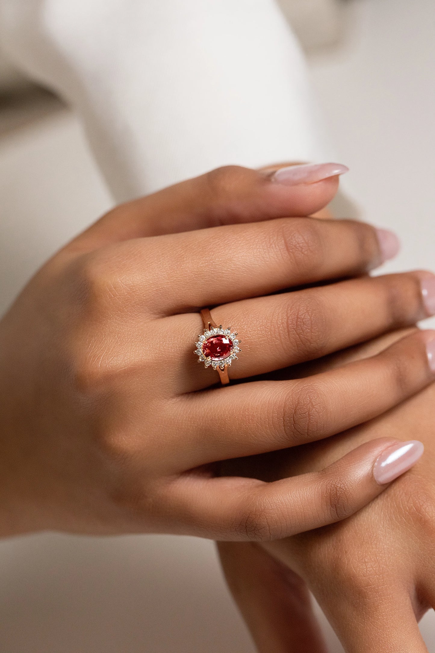 Exquisite 18K gold engagement ring featuring a 1.32ct unheated Ceylon Padparadscha sapphire, surrounded by a delicate diamond cluster for a timeless, elegant design.