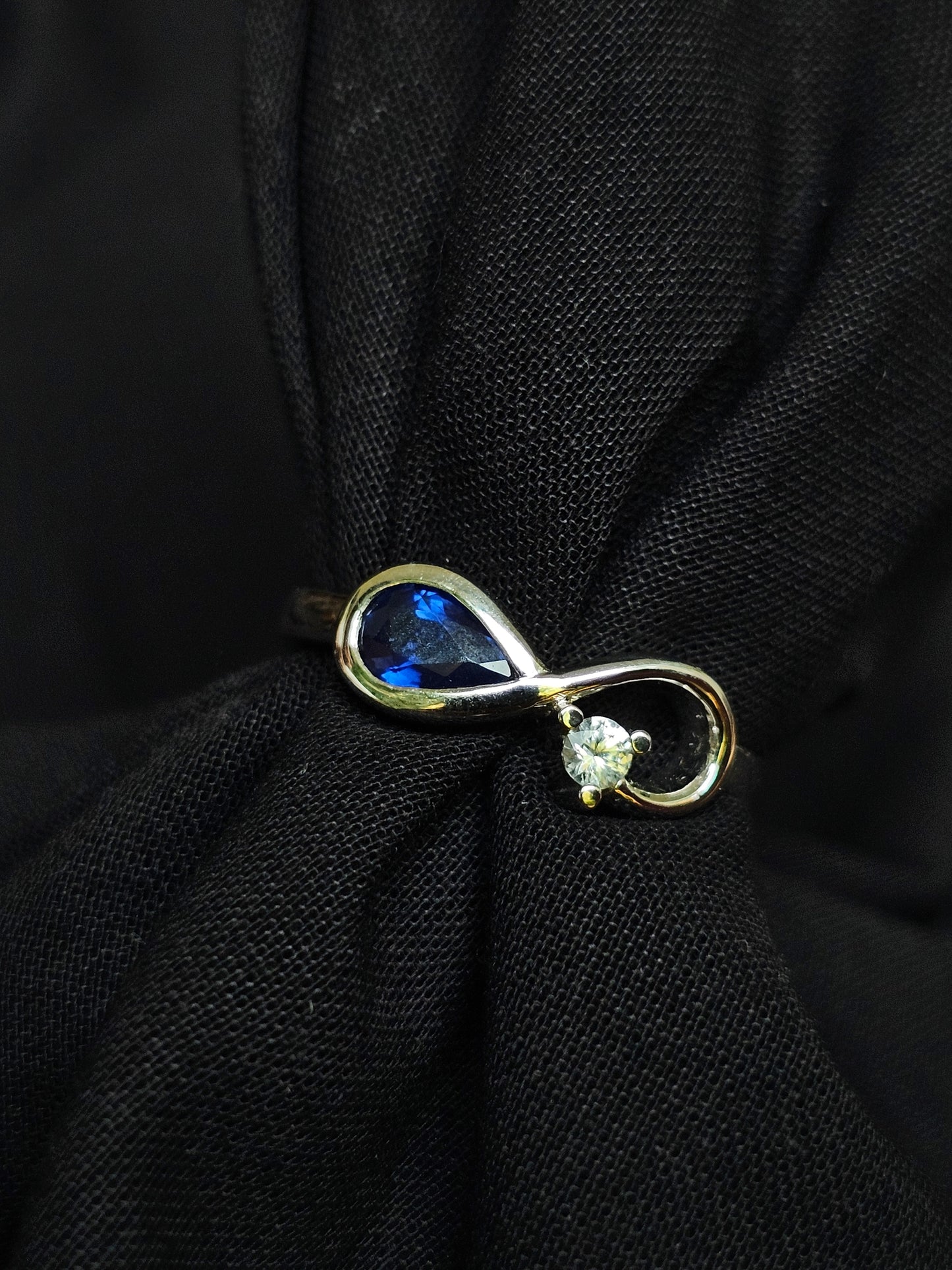 Infinity ring crafted in gold with repurposed gemstones from a sentimental engagement ring, made for everyday elegance.