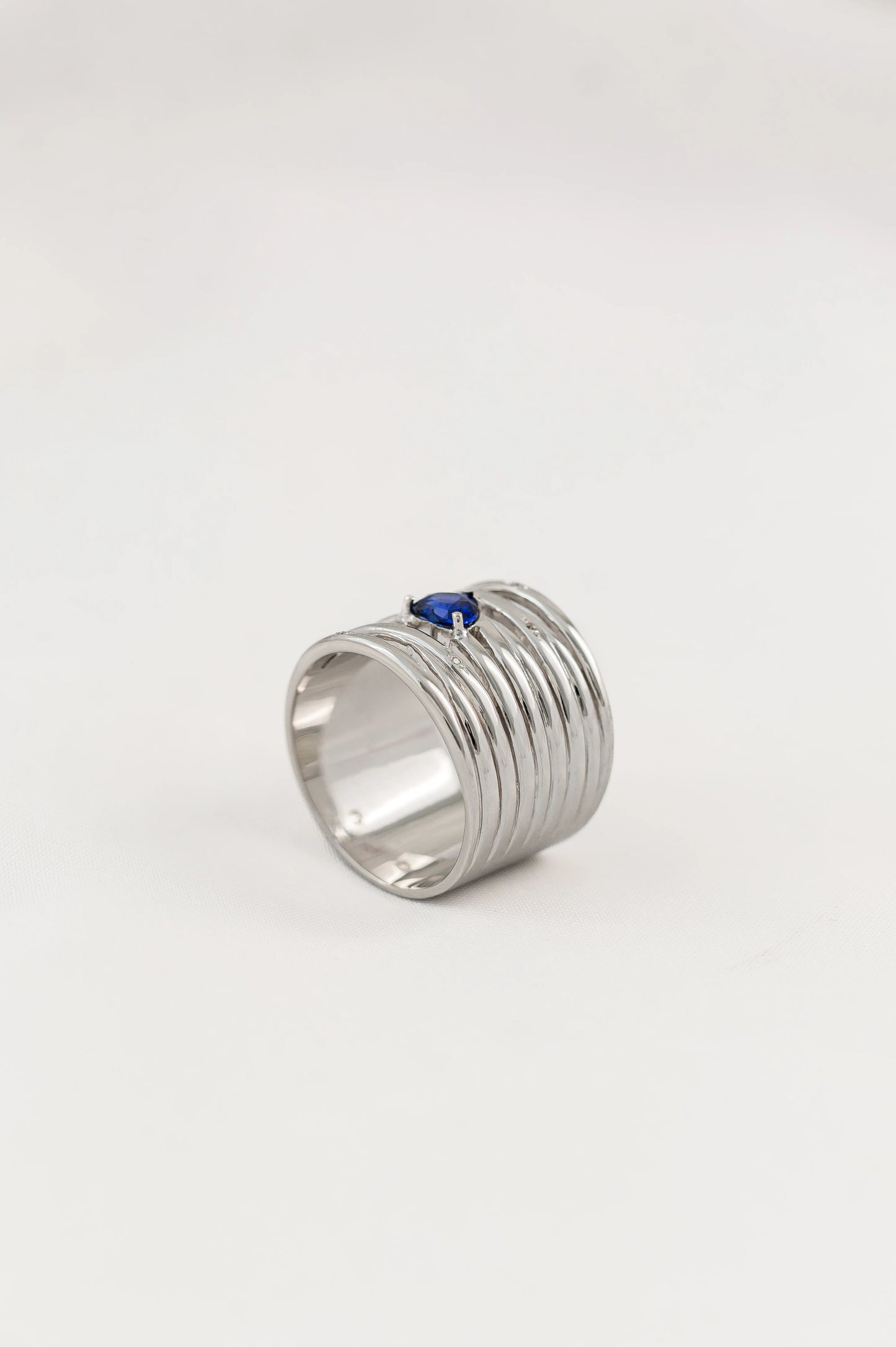 Close-up of custom 18K white gold ring featuring a heart-shaped Royal Blue Sapphire from Sri Lanka, beautifully complemented by diamonds, crafted for a sentimental gift.