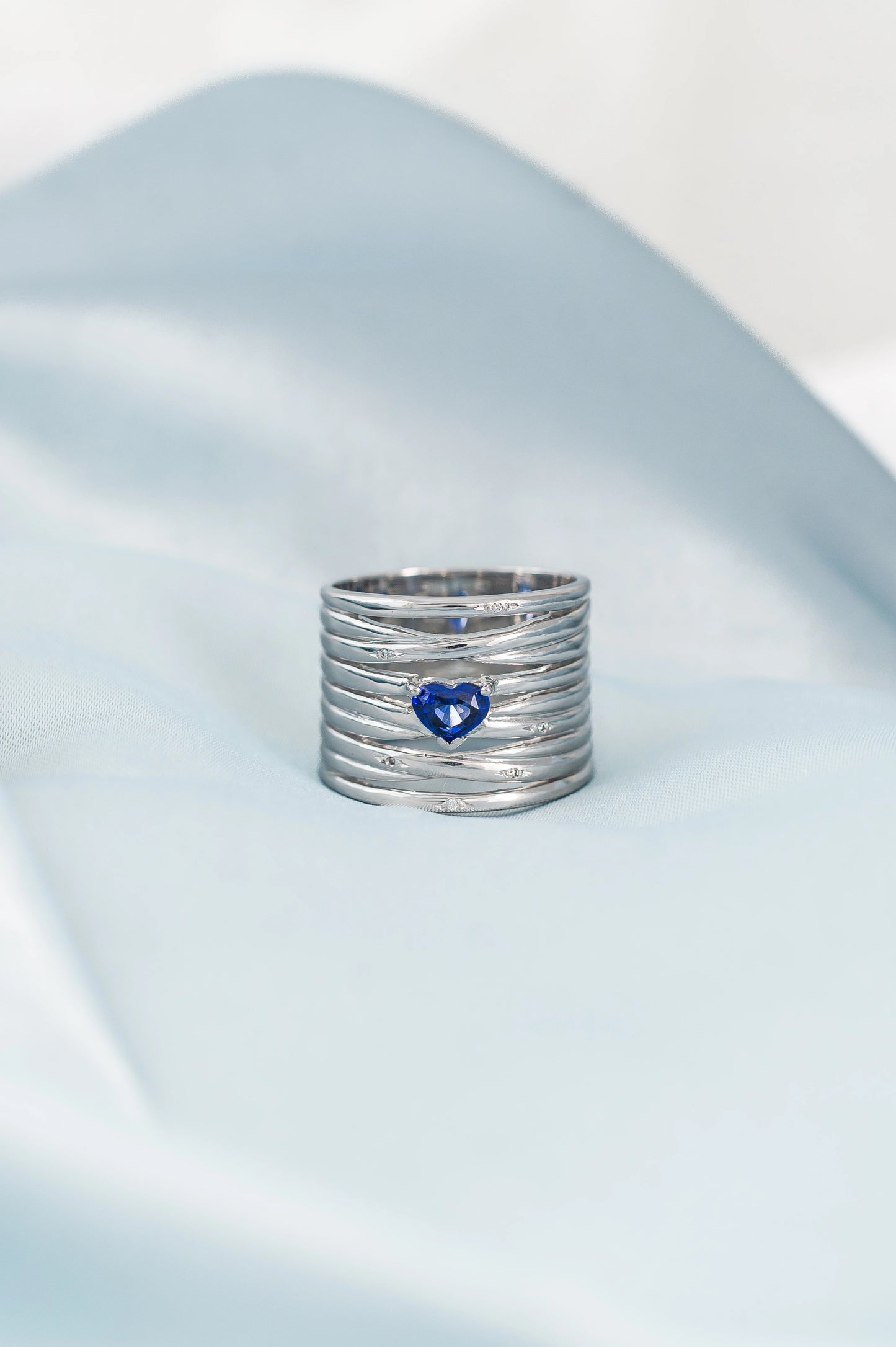 Custom-made 18K white gold ring featuring a heart-shaped Royal Blue Sapphire from Sri Lanka, accented with delicate diamonds, a meaningful gift crafted with love and care.