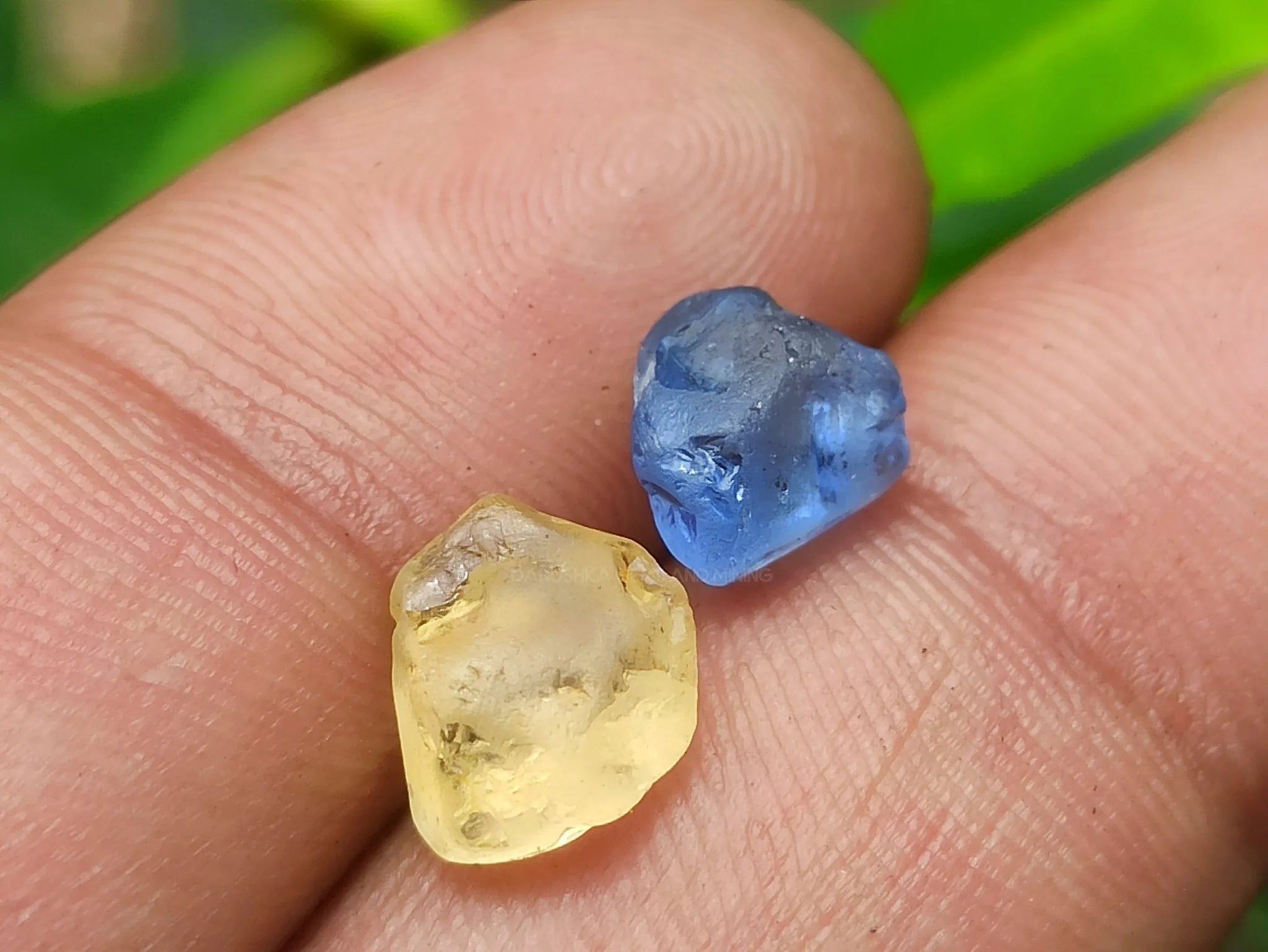 Collection of rough gemstones, freshly mined in Sri Lanka, displaying their natural textures and colors before the cutting process.