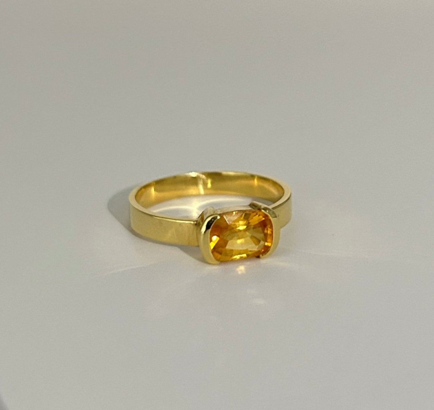 Minimalist 14K yellow gold ring with a 1.24ct yellow sapphire from Sri Lanka, set in a secure bezel setting, radiating timeless elegance.