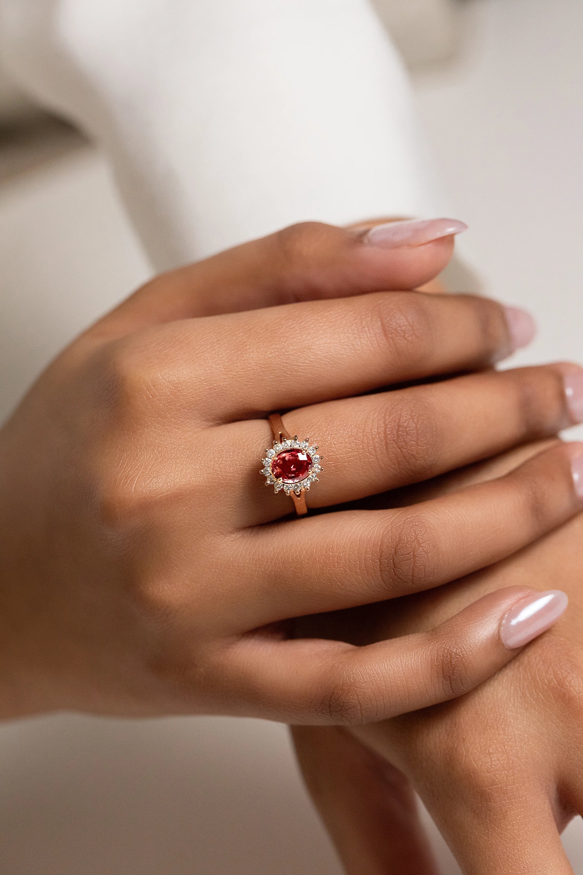 Exquisite 18K gold engagement ring featuring a 1.32ct unheated Ceylon Padparadscha sapphire, surrounded by a delicate diamond cluster for a timeless, elegant design.