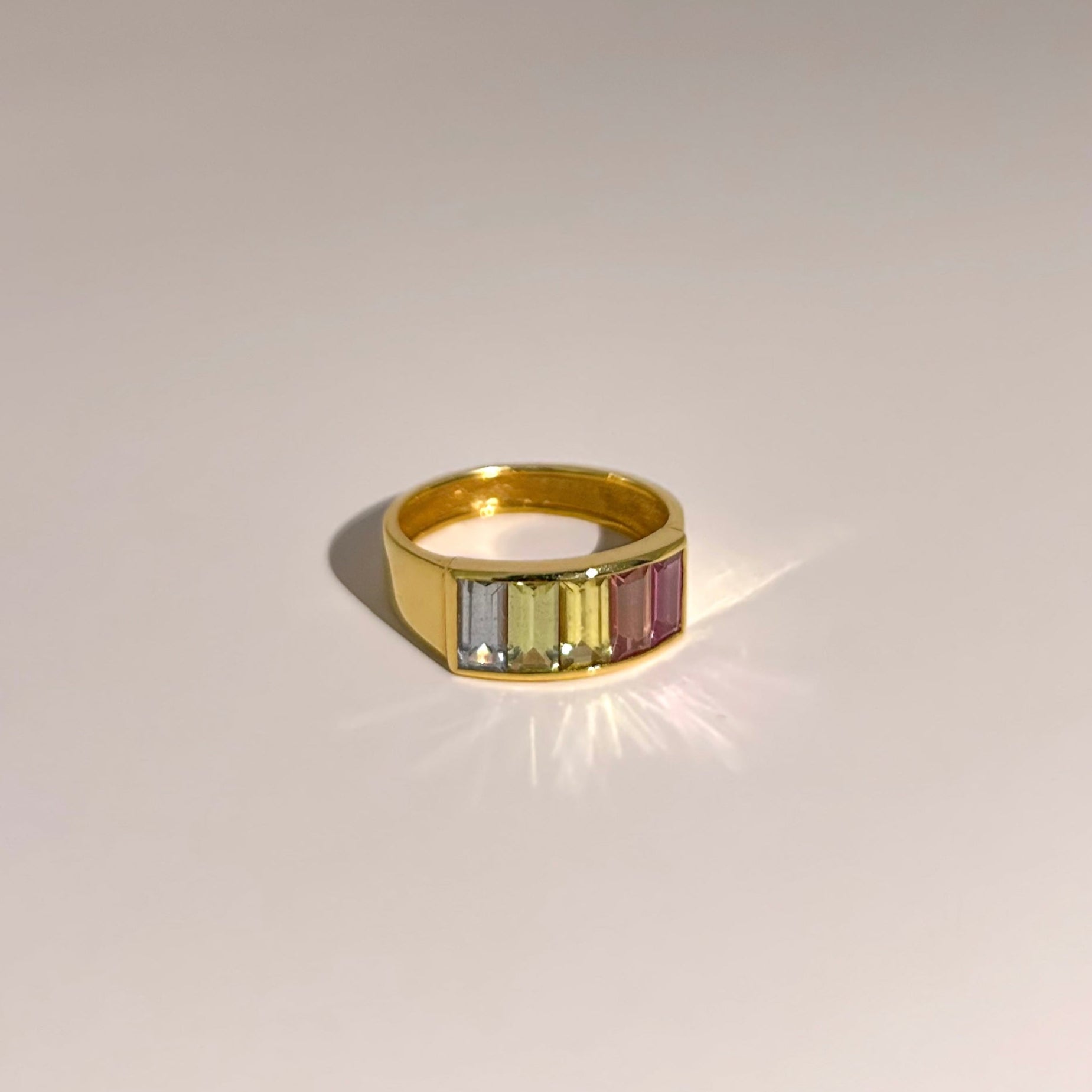 Elegant 18K yellow gold band featuring five pastel sapphires from Madagascar (1.86ct total), cut in baguette shapes and set in a channel setting for a sophisticated and versatile look.