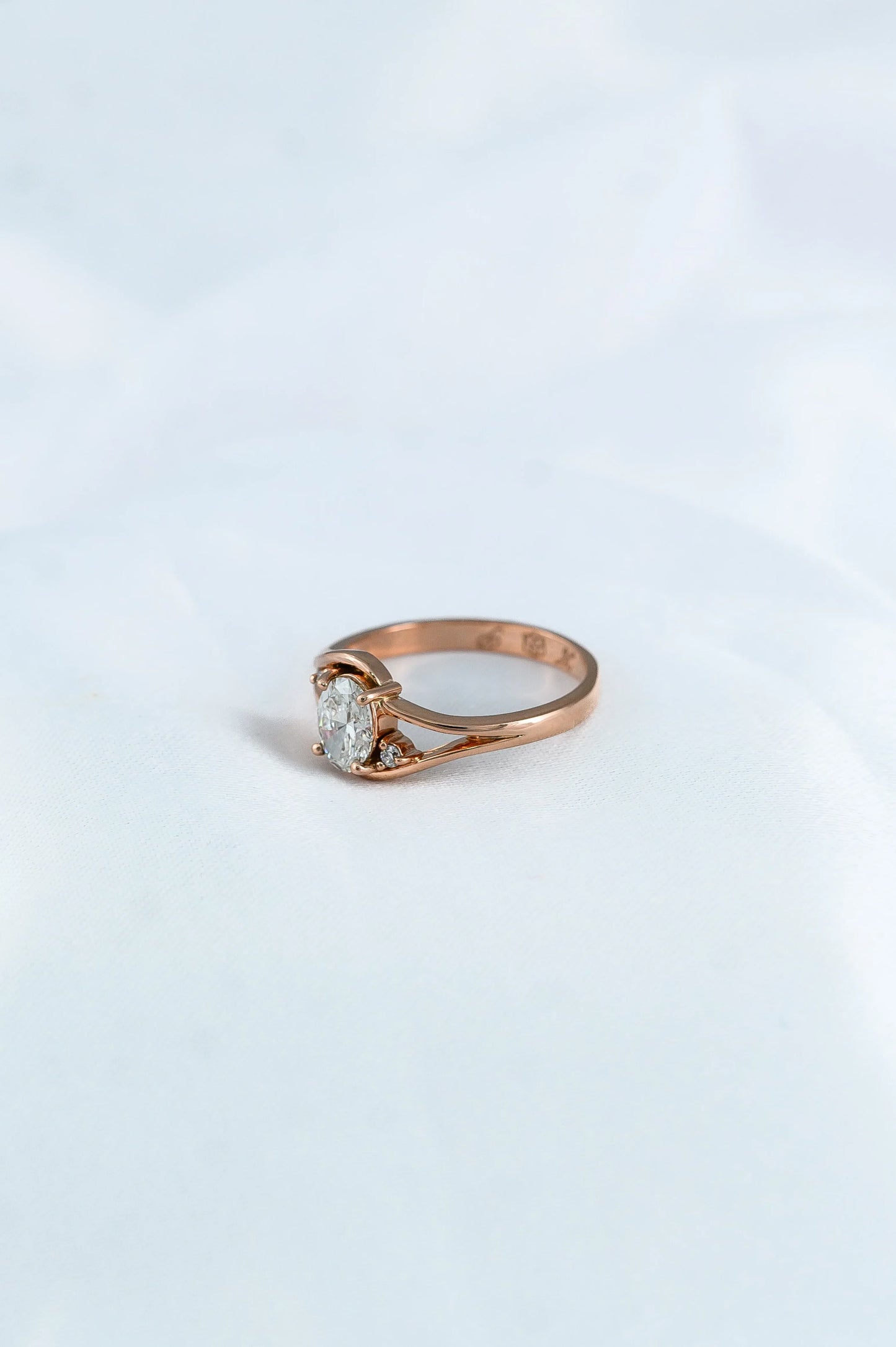 Custom rose gold engagement ring with oval diamond trio, thoughtfully crafted to celebrate a couple’s love story.
