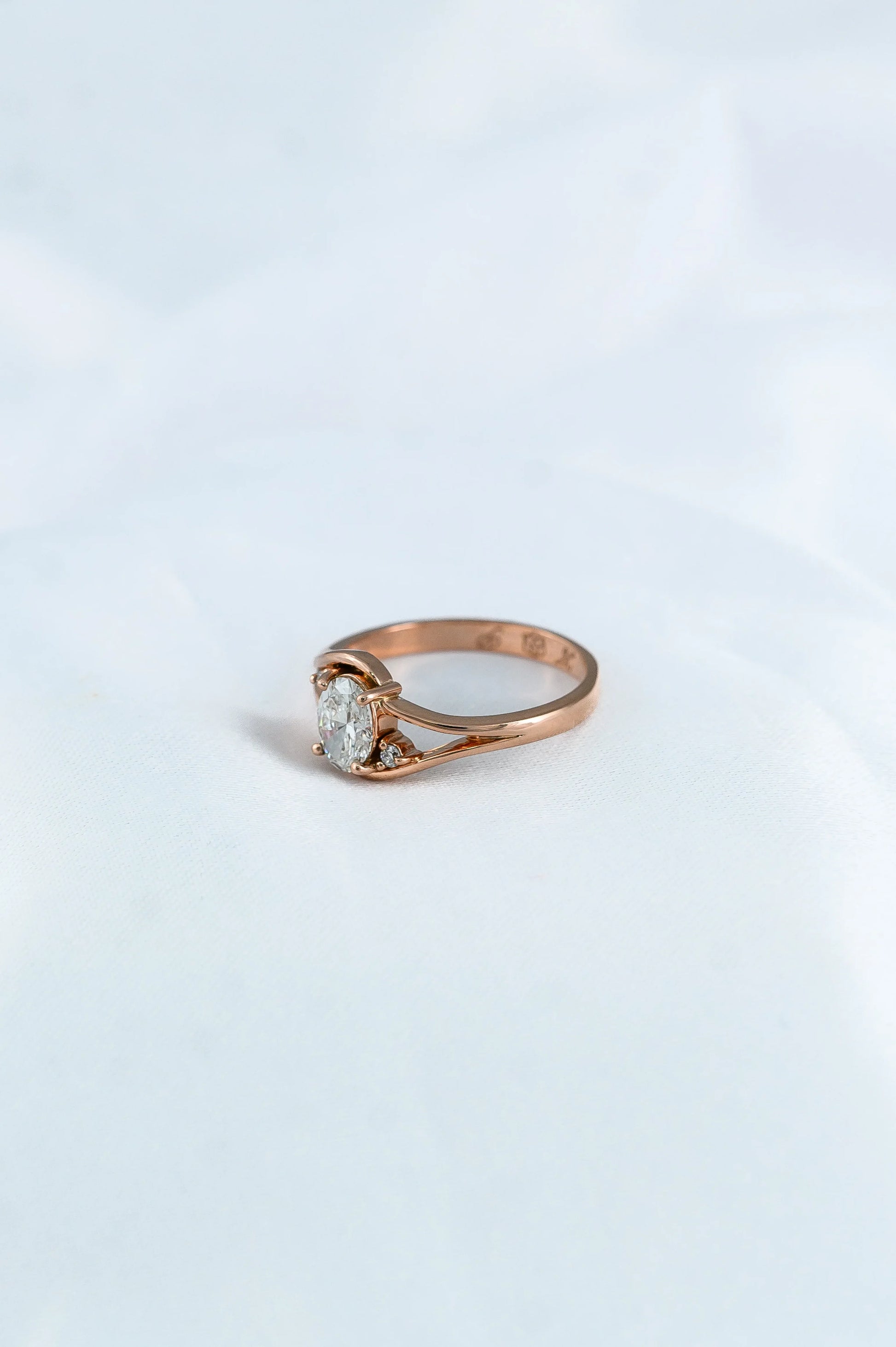Custom rose gold engagement ring with oval diamond trio, thoughtfully crafted to celebrate a couple’s love story.