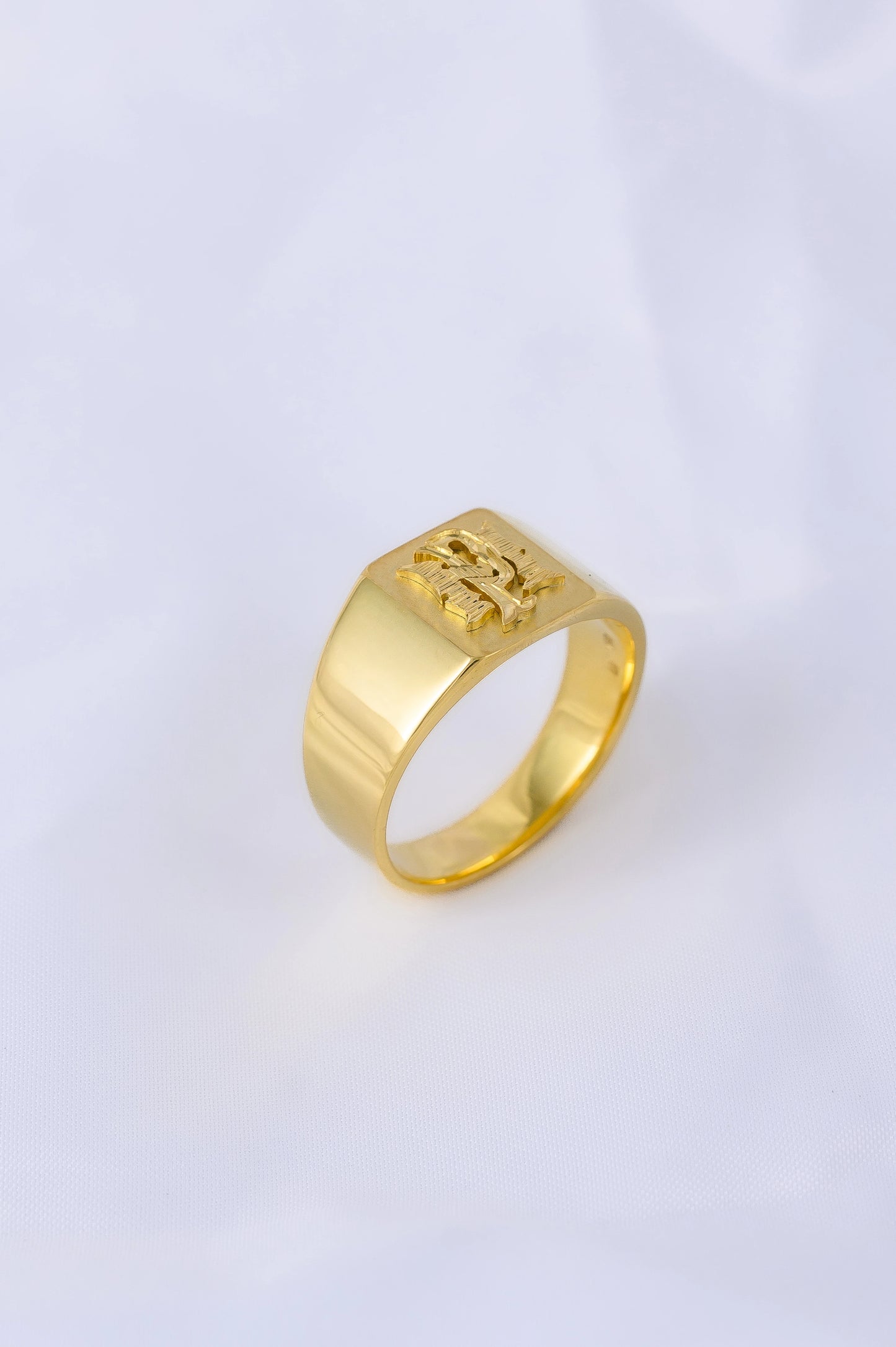 Handcrafted signet ring in 18K gold with intricate design, symbolizing family legacy and personal identity.