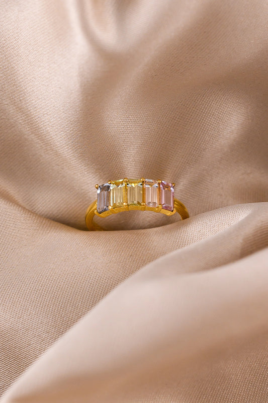 Custom 5th anniversary ring crafted with delicate pastel-hued sapphires, set in 18K gold to symbolize love and lasting joy.