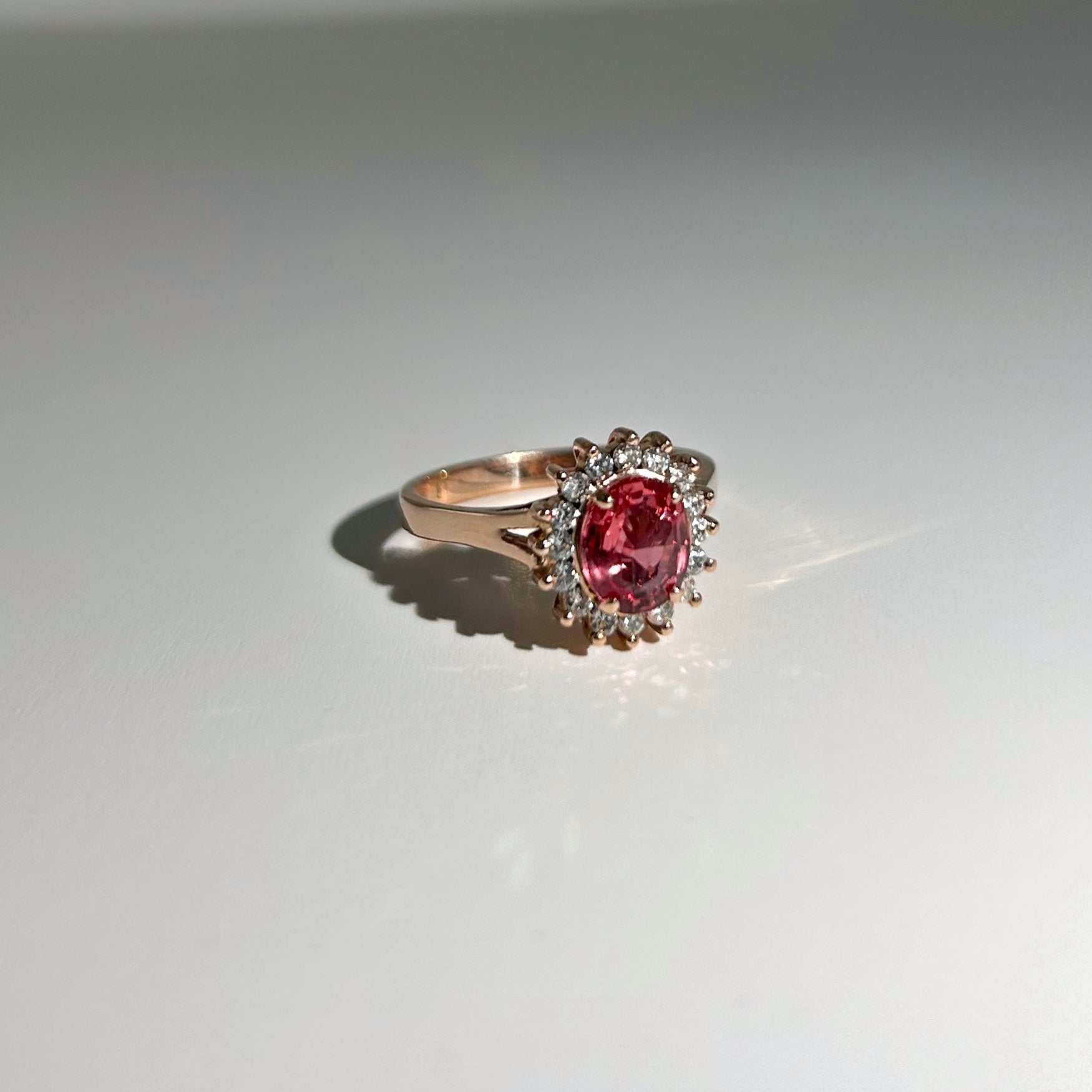1.32ct unheated Ceylon Padparadscha sapphire surrounded by diamonds, set in a unique and timeless design, perfect for any occasion.