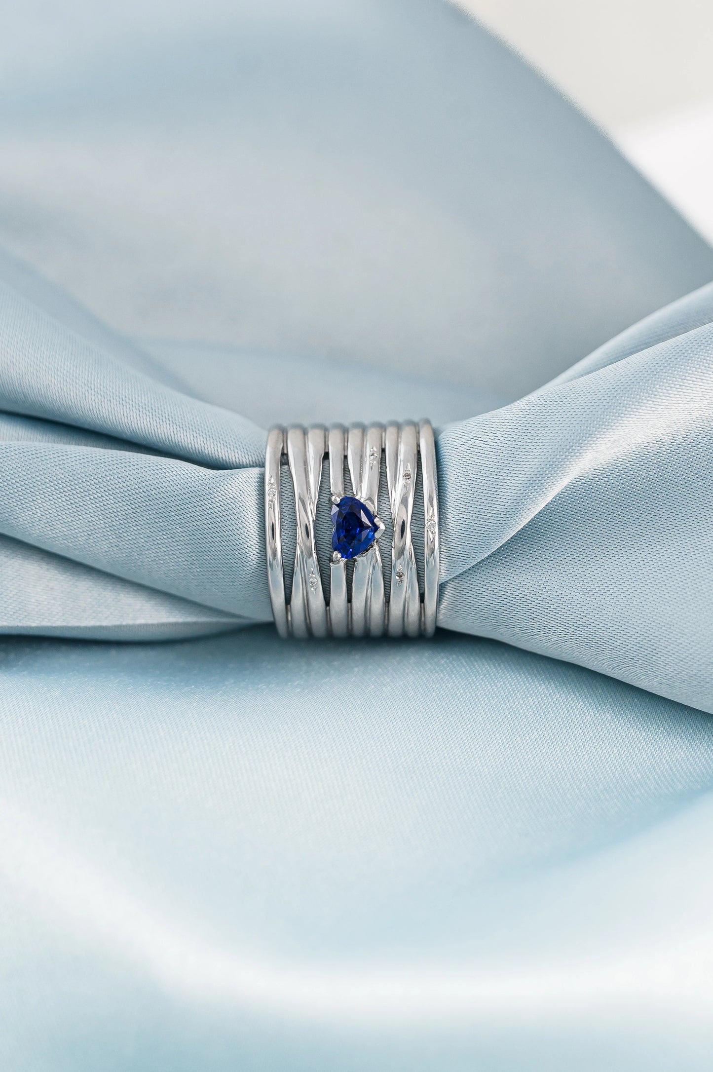 Bespoke 18K white gold ring with a heart-shaped Royal Blue Sapphire from Sri Lanka, enhanced with diamonds, symbolizing love and sentiment.