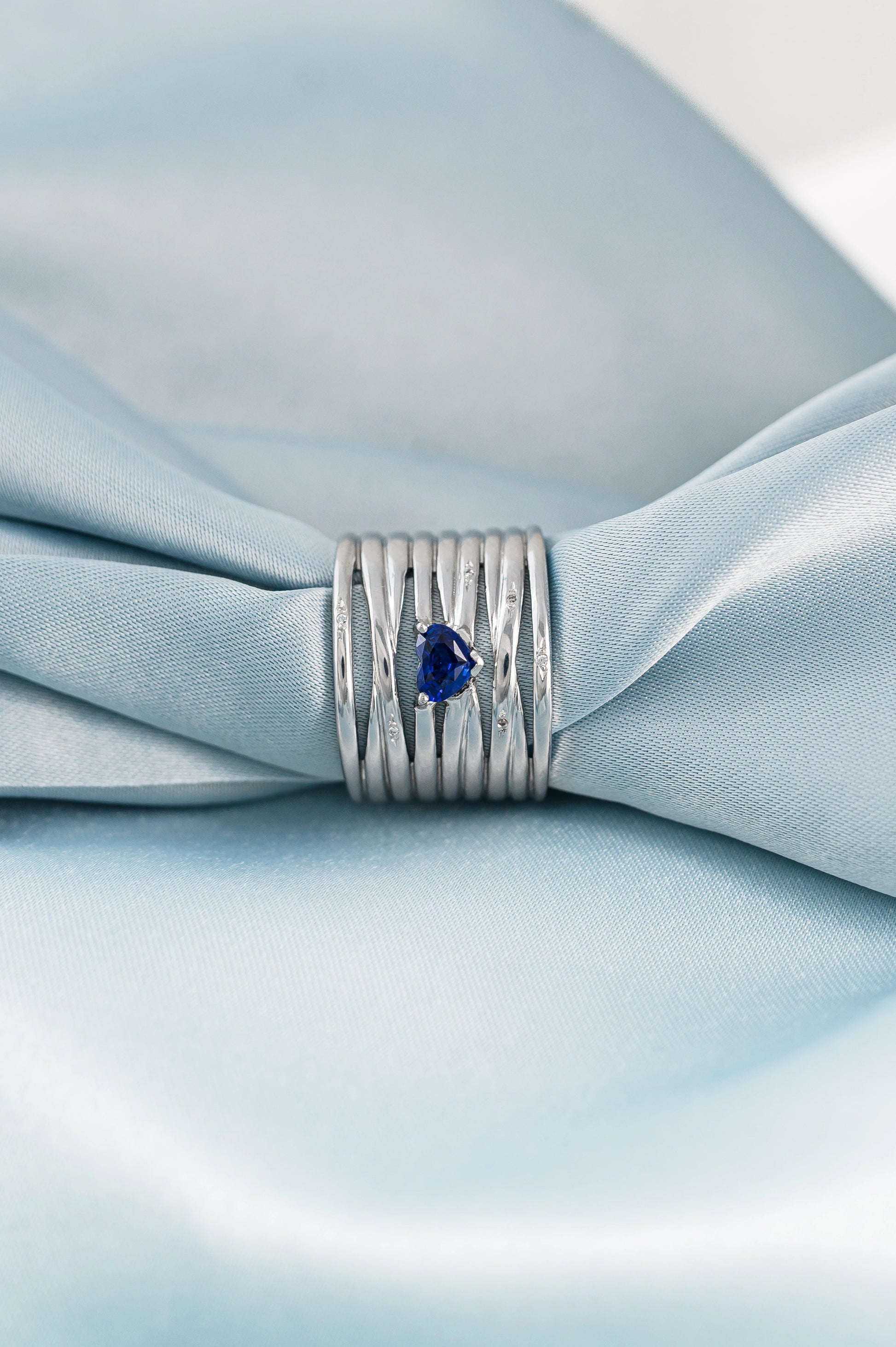 Bespoke 18K white gold ring with a heart-shaped Royal Blue Sapphire from Sri Lanka, enhanced with diamonds, symbolizing love and sentiment.