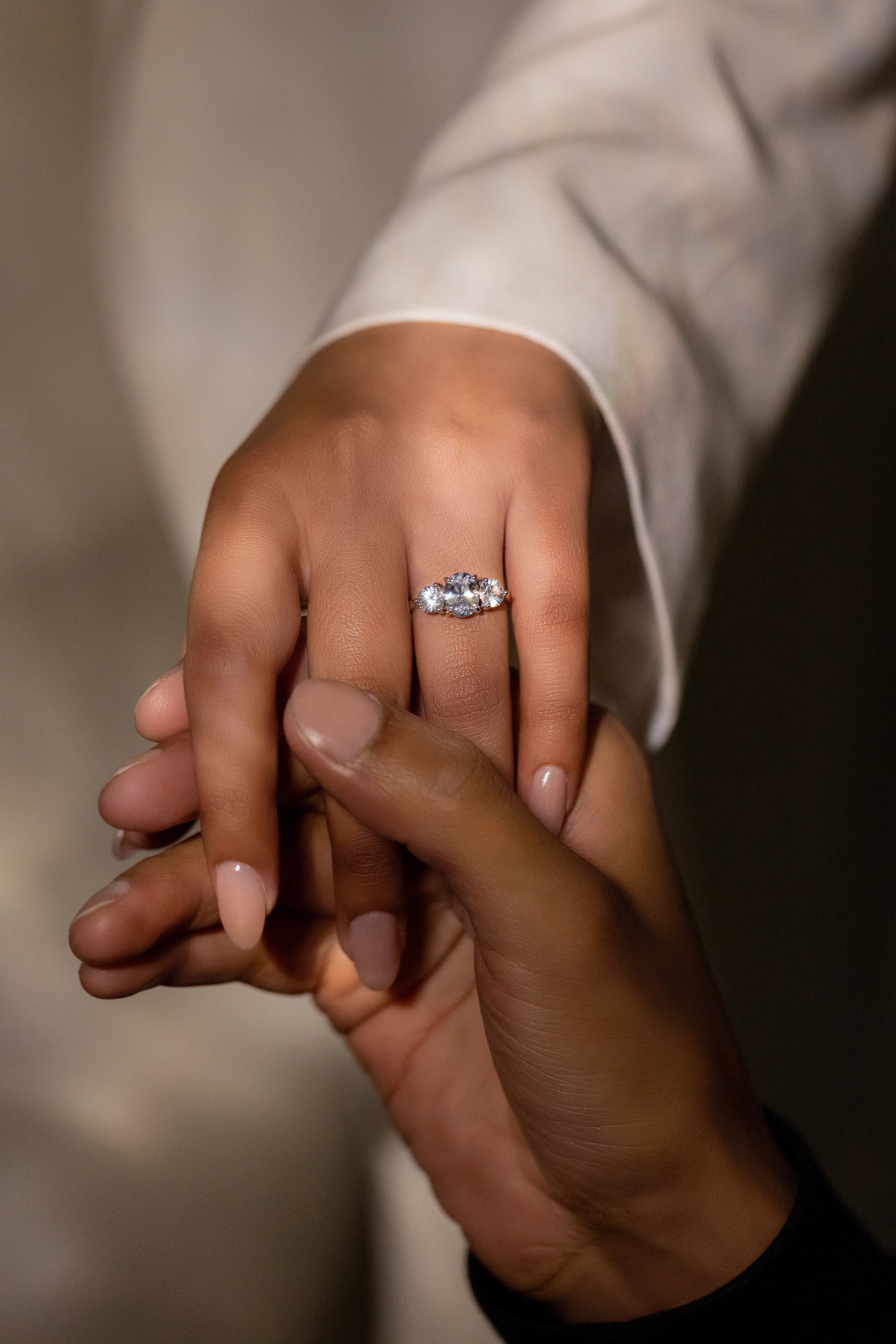 18K white gold engagement ring with 1.4ct unheated white sapphire and two 0.5ct side sapphires, worn by the modern bride in a timeless and elegant setting.